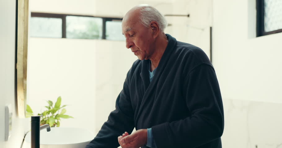 Senior man, bathroom or medication with water for medical symptoms or chronic illness in home. Elderly, male person or drinking with mineral liquid or pills for prescription, antibiotic or supplement