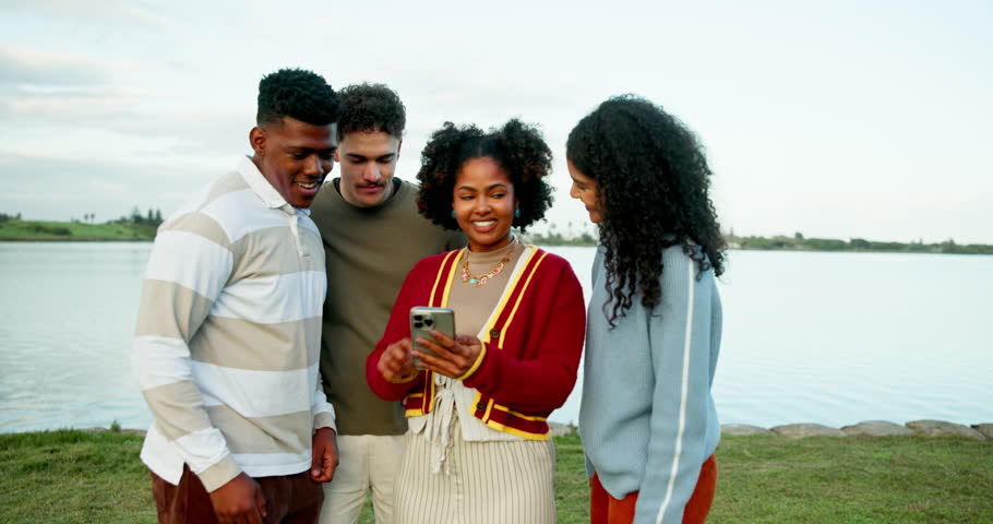 Laughing, phone and text message with friends outdoor together for celebration or success. App, mobile search and social media with group of funny student people in nature for college acceptance