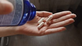 person pouring white supplement tablets from a blue bottle into their hand. Daily health care, vitamin intake, medication or nutritional supplement routine. Sport nutrition supplement  - Powered by Shutterstock - Get 15% off with code: PIKWIZARD15