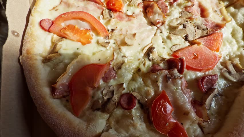 tasty traditional Italian pizza carbonary freshly baked pizza with melted cheese, tomato slices mushrooms, bacon, and sausage on golden crust. Creamy base pizza. Melted cheese and bacon strips pizza