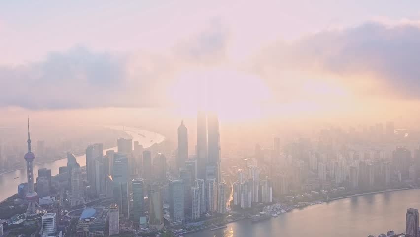 Watch as the sun rises over Shanghai, casting soft light through morning mist and unveiling the city