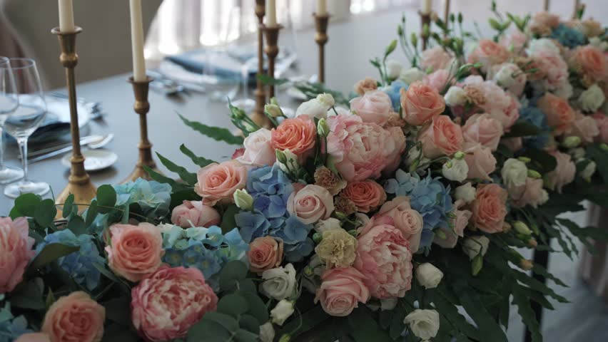 elegant table arrangement with pastel roses hydrangeas and peonies for a wedding reception