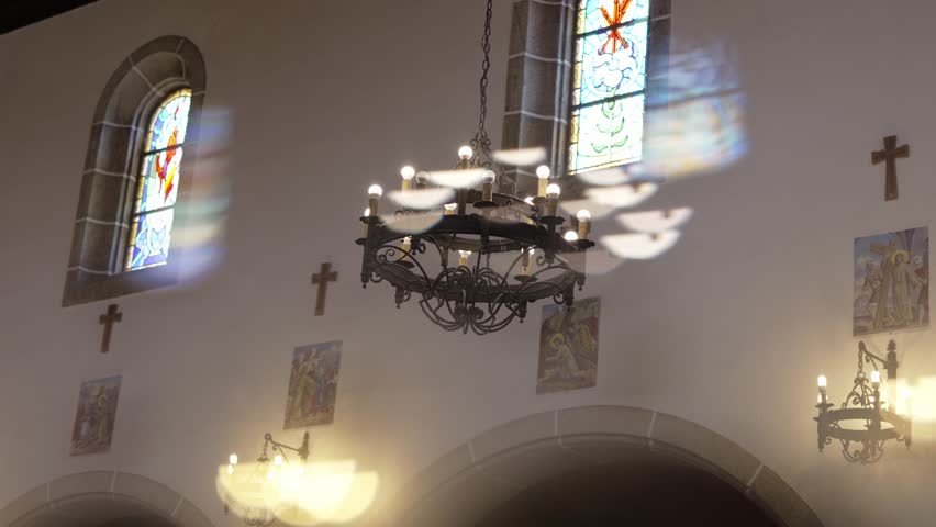 sunlight casts vivid colors through stained glass windows onto church walls and chandelier - Powered by Shutterstock - Get 15% off with code: PIKWIZARD15