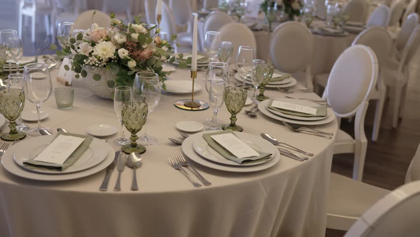 round banquet table with floral centerpiece and formal tableware set for wedding reception
