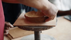 A close-up of a person's hands crafting a small, rustic bowl using a traditional hand-building pottery technique in a creative workshop or art class. - Powered by Shutterstock - Get 15% off with code: PIKWIZARD15
