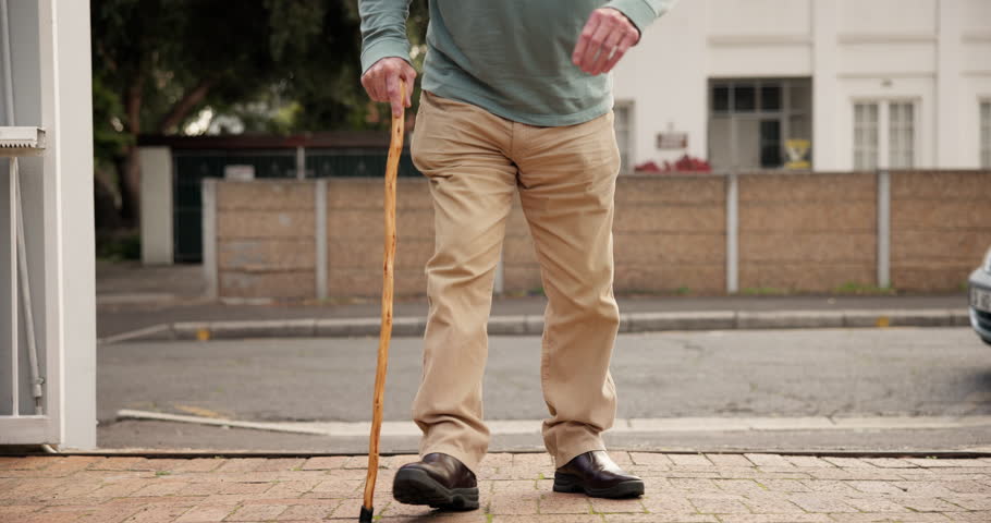 Outdoor, walking stick and old man with retirement, legs and movement with wellness. Closeup, pensioner and elderly person with disability, cane and healthy with mobility support for arthritis