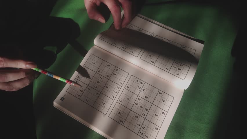 Person concentrating in study room with brain teaser numbers puzzle TOP DOWN