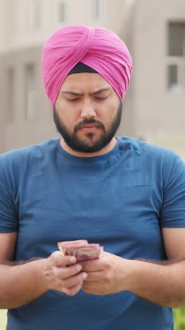 Vertical Video of Confussed Sikh Indian Man Counting Money, 2000 Indian Rupees