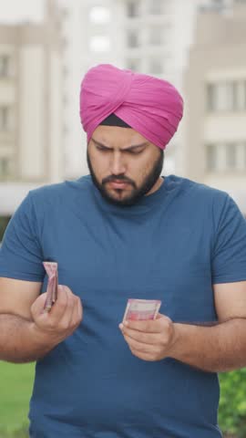 Vertical Video of Confussed Sikh Indian Man Counting Money
