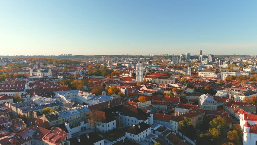 Beautiful aerial Vilnius city Old town panorama in autumn with orange and yellow foliage. Aerial sunny evening view. Cathedral of the Theotokos. Fall city scenery in Vilnius, Lithuania