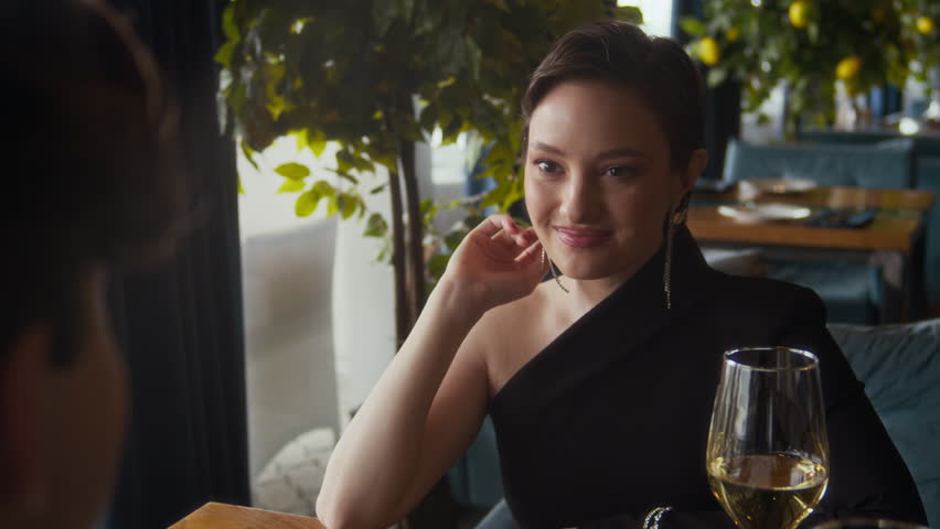 Tilt up shot of young man giving spoonful of sophisticated dessert to girlfriend at table having date with wine in fine dining restaurant