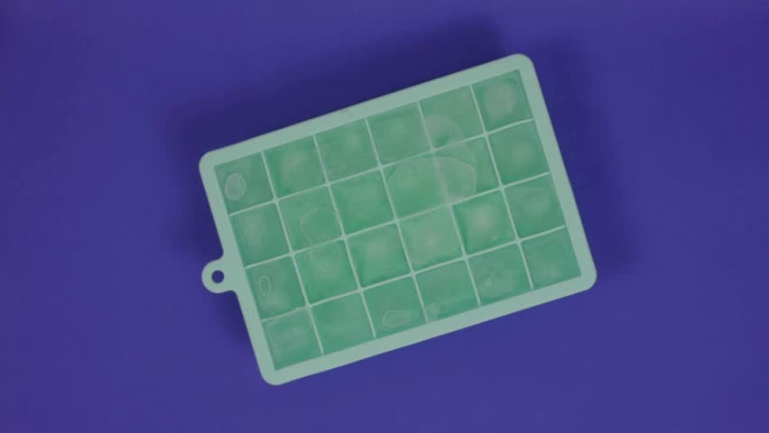 Frozen Ice Cubes in Colorful Silicone Trays on Yellow Background – Visual Concept of Freezing and States of Matter in 4K Ultra HD