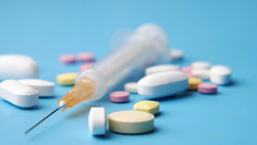 syringe and assorted pills 4k - Powered by Shutterstock - Get 15% off with code: PIKWIZARD15