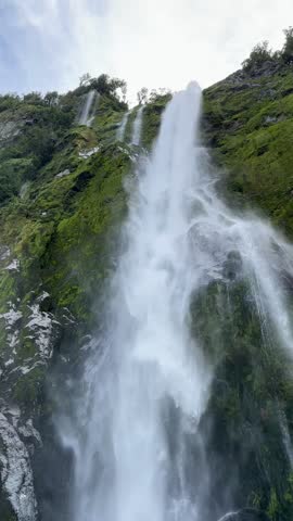  Picturesque view of the waterfall from the water. Cruise on a boat in Milford Sound, New Zealand.