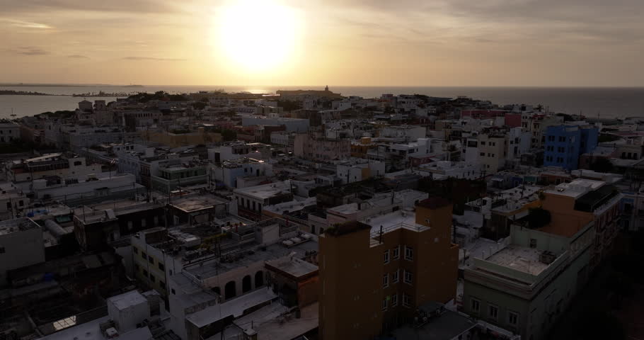 A golden hour view of Old San Juans coastline with soft sunset light and historic architecture