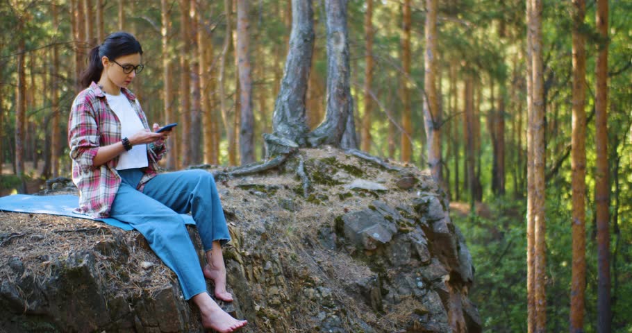 Relax with the breath of the morning forest. Young woman is meditating in a morning pine forest. Solitude with your thoughts and nature. Nature as a path to mental health. Slow motion 4k footage.
