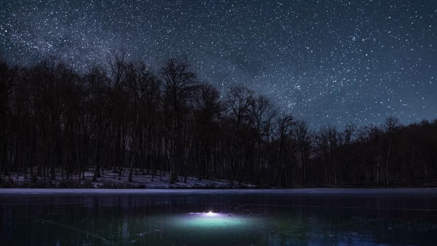 Beautiful night landscape with small frozen lake in the forest.