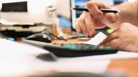 Modern office. Male hand using calculator and filling out papers. Close-up. FHD video. Close-up Businessman using calculator while working with financial reports at office. - Powered by Shutterstock - Get 15% off with code: PIKWIZARD15