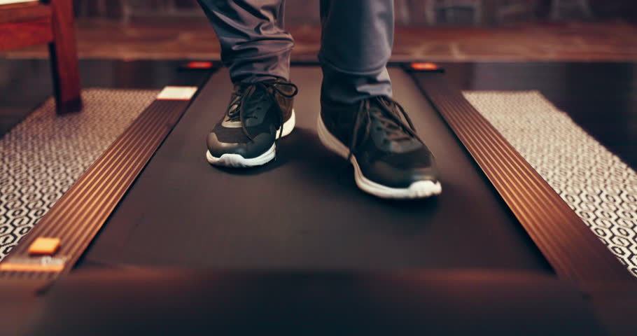 Legs, treadmill and walking with person in home for activity, exercise or fitness routine. Physiotherapy, rehabilitation and wellness with feet in apartment for action, cardio training or health
