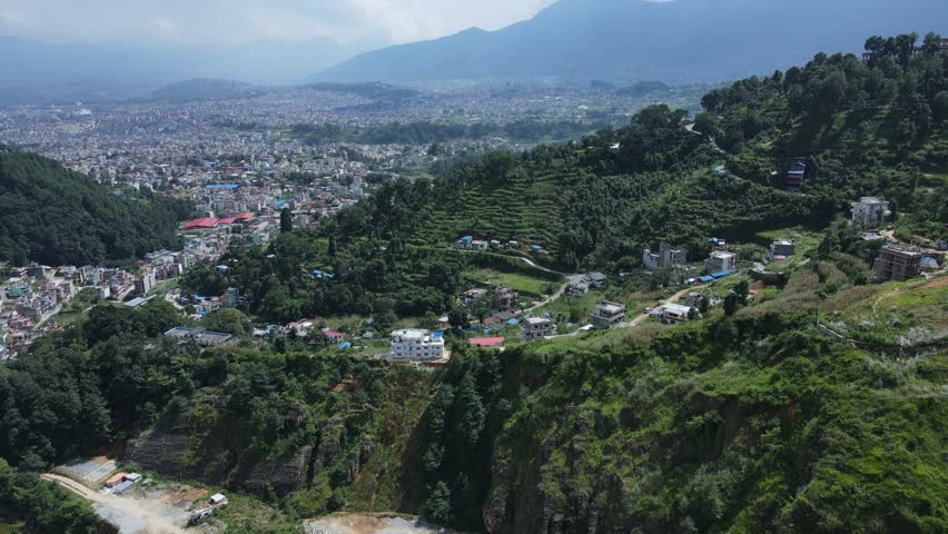 Aerial drone footage of Kathmandu, Nepal’s capital, showcases city life, historic architecture, and scenic skies filled with white clouds offering a peaceful contrast to the dense urban landscape.