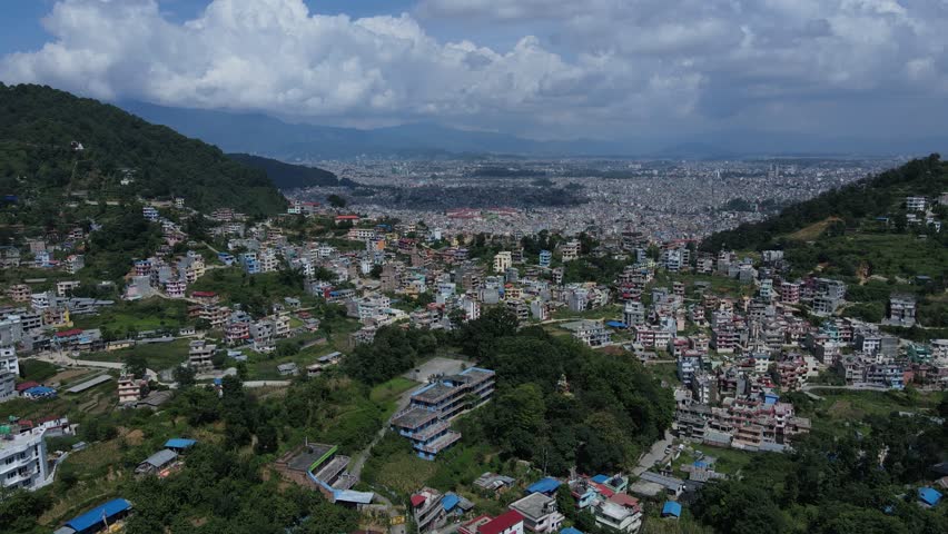 Aerial drone footage of Kathmandu, Nepal’s capital, showcases city life, historic architecture, and scenic skies filled with white clouds—offering a peaceful contrast to the dense urban landscape.