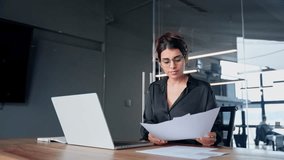 Focused busy female latin or arabian young business woman hr working on laptop computer reading finance document report, contract in office. Saleswoman manager businesswoman doing paperwork using pc - Powered by Shutterstock - Get 15% off with code: PIKWIZARD15