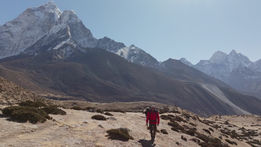 Trekker's Journey Through the Himalayas: A Stunning View of Mount Everest from the Base Camp in Nepal