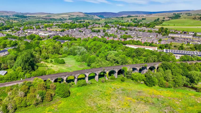 A close up rotating aerial view of the viaduct over the River Sett at New Mills, Derbyshire, UK in summertime