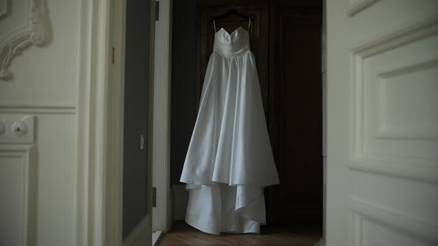 White wedding dress hanging on wardrobe door