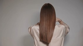 Woman shows healthy strong and shiny hair after keratin haircare treatment procedure in salon hairdresser. - Powered by Shutterstock - Get 15% off with code: PIKWIZARD15