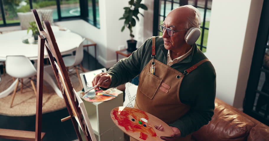 Headphones, senior man and painting for art in home, inspiration song and dancing for talent. Elderly person, music and artist with brush for retirement hobby, creative drawing and listening to audio