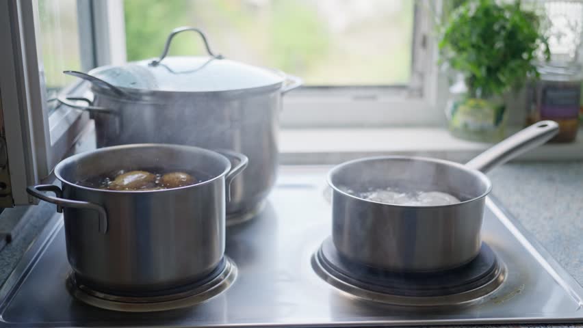 A lively kitchen with bubbling pots, boiling water, and steaming ingredients ready for cooking delicious meals. Slow motion