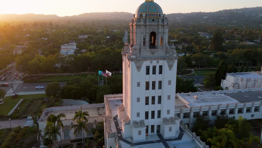Golden hour close-up orbit of Beverly Hills City Hall with scenic hills in background