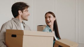 Couple preparing for relocation as they carry moving boxes in new apartment - Powered by Shutterstock - Get 15% off with code: PIKWIZARD15