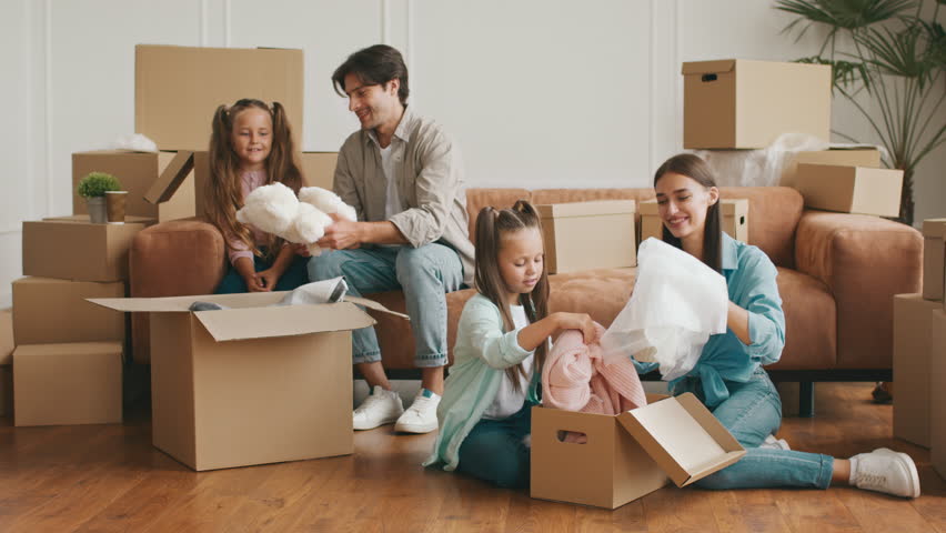 Family enjoys relocation and unpacking boxes in new apartment together