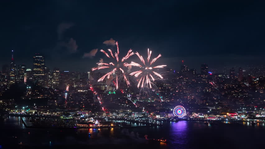 An aerial view captures vibrant fireworks illuminating the San Francisco skyline on Independence Day, showcasing a magnificent display of colors and lively celebrations that embody the holiday spirit