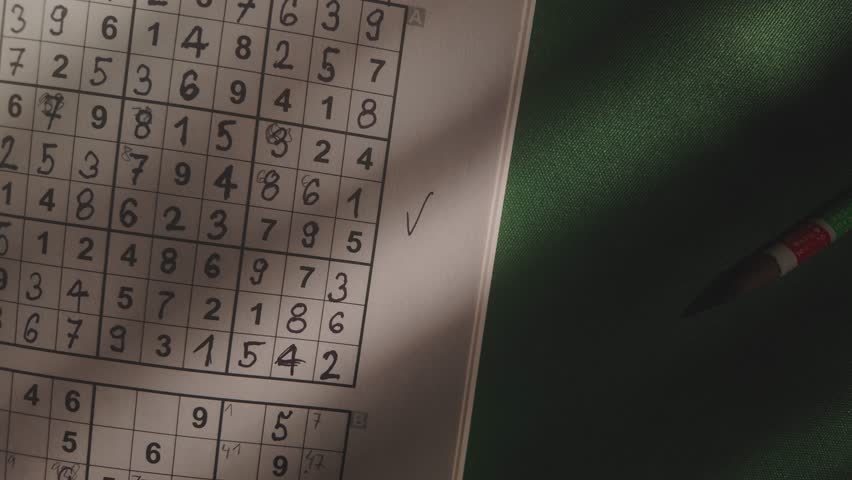 Solved Suduku numbers puzzle revealed in dimly lit study TOP DOWN shot