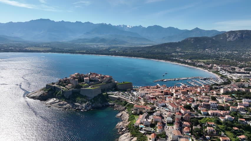 Calvi Citadel and Old Town Framed by Beach, Harbor, and Mountain Range
