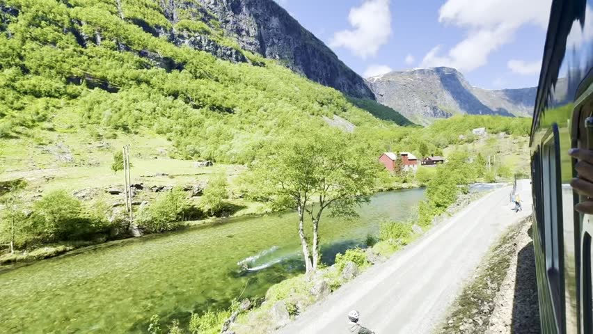 Scenic Flåm train ride in Norway passing stunning mountains and crystal-clear lakes—ideal for travel, nature, and landscape stock photos capturing Nordic beauty.