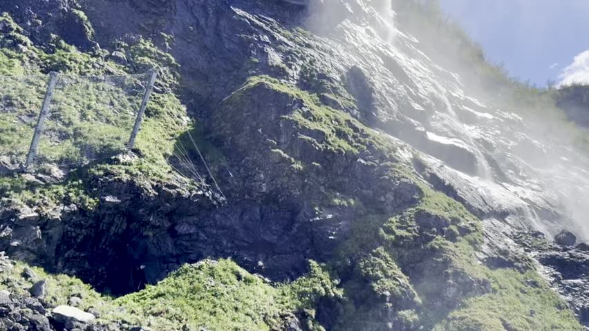 Kjosfossen waterfall thunders beside Norway’s Flåm Railway, spraying mist over lush cliffs and rocky gorge—ideal for dramatic nature, travel, and landscape stock photography.
