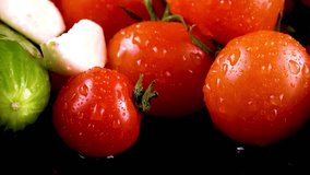 Fresh red tomatoes with water droplets and garlic placed on a black reflective surface. The glistening vegetables emphasize freshness, organic produce, and healthy food concepts. Ideal for culinary 4k - Powered by Shutterstock - Get 15% off with code: PIKWIZARD15