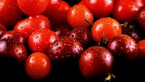 Close-up of fresh red cherry tomatoes with water droplets against a black background. The vibrant and glossy surface highlights freshness, organic produce, and healthy eating concepts. 4k - Powered by Shutterstock - Get 15% off with code: PIKWIZARD15