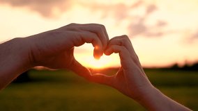 People love. Heart with fingers symbol Valentine's Day. Happy couple man woman making heart gesture with fingers in sun park. Married couple man woman joined fingers in heart shape outdoors at sunset - Powered by Shutterstock - Get 15% off with code: PIKWIZARD15