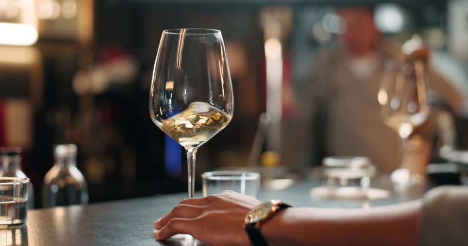 Hands, person and swirl alcohol in glass for taste testing, quality control and sensory ritual. Customer, inspection and wine expert of aroma, balance flavour and evaluation process to prepare palate