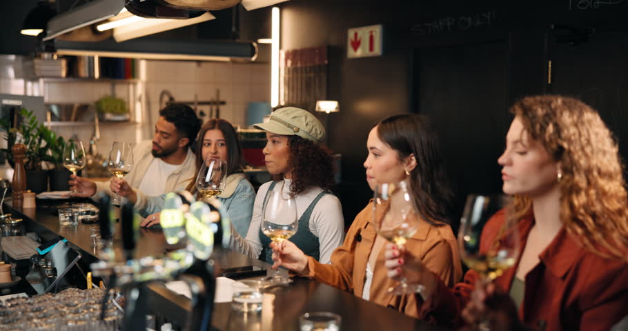 People, drinking and wine in glass at bar for taste testing, quality control and experience. Row, customer and alcohol beverage for happy hour, prepare palate and hospitality industry at brewery pub