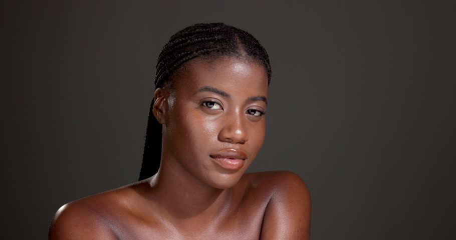 Face, beauty glow and black woman in studio with makeup, confidence and healthy skin. Dermatology cosmetics, proud or African person isolated on gray background with shine, mockup space and wellness