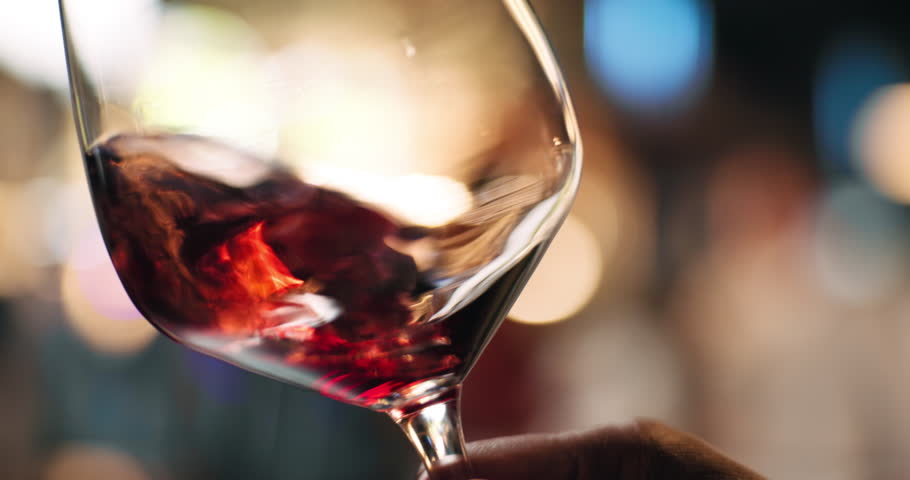 Hands, person and swirl red wine in glass for taste testing, quality control and sensory ritual. Customer, inspection and alcohol for aroma, balance flavour and evaluation process to prepare palate
