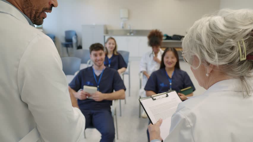 Medical students raising hands during hospital lecture in slow motion