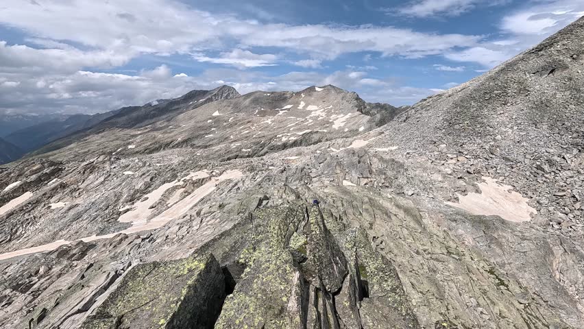 Rugged alpine ridge with rocky slopes under dramatic storm clouds in the Monte Rosa area, Italian Alps.