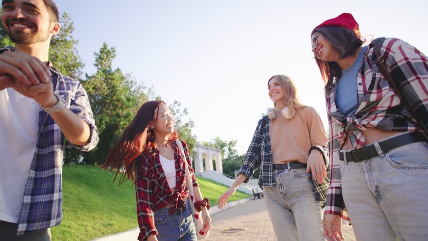 Friends celebrating a sunny day in the park with playful games rock paper scissors while wearing casual outfits and enjoying each others company in the afternoon light